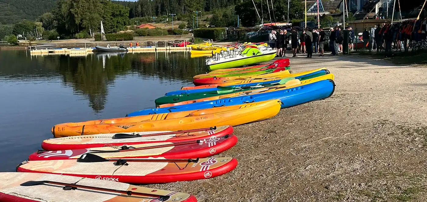 Paddles et kayaks alignés sur la rive, à la base du lac des Vieilles-Forges